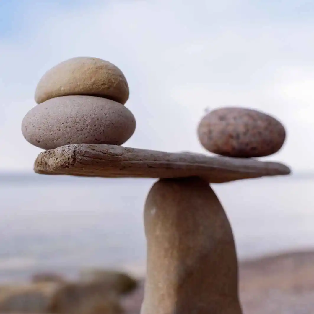 Piedras lisas acomodadas como una balanza donde se puede asociar a una comparación de los dos distintos tipos de software.